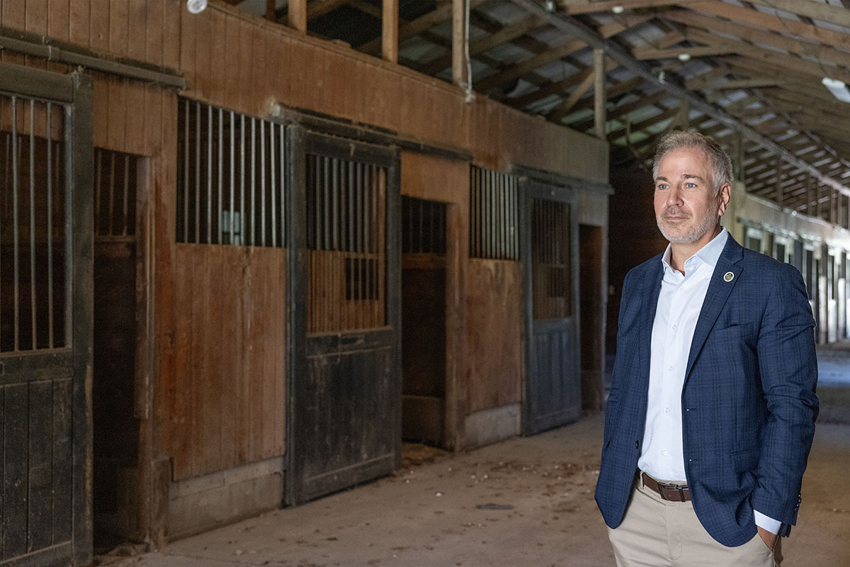 Marc Orlando in Sport Coat standing in the horse paddocks