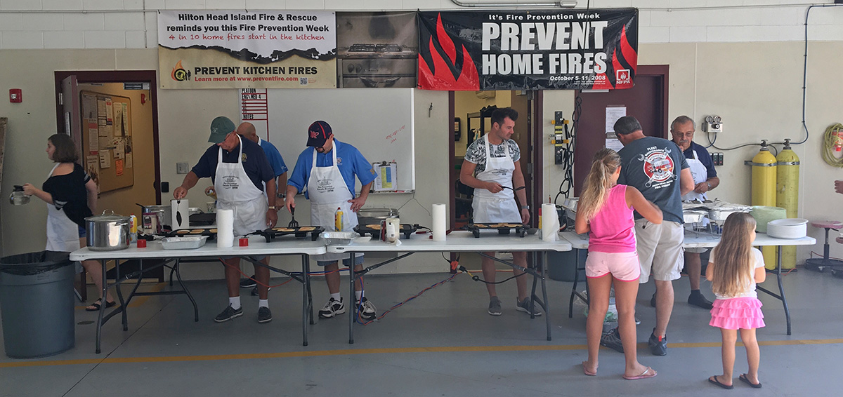 volunteers cooking and serving pancakes