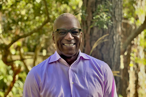 Headshot of Zenos Morris outside in front of a tree